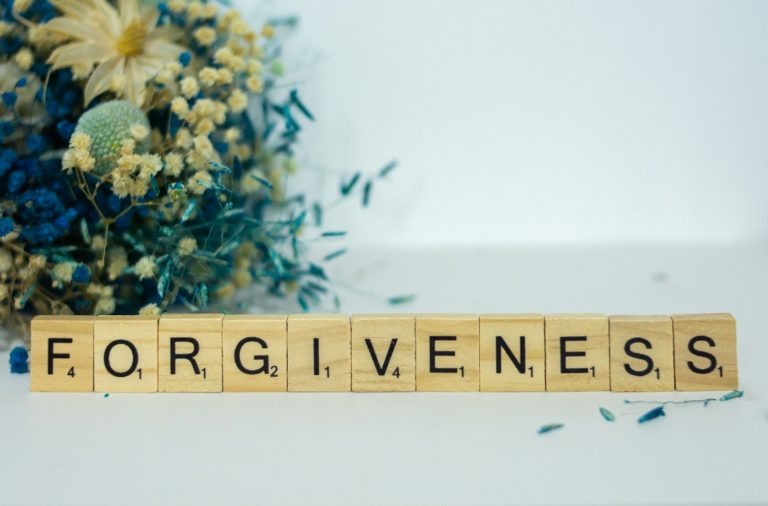 a scrabble type block spelling out the word forgiveness